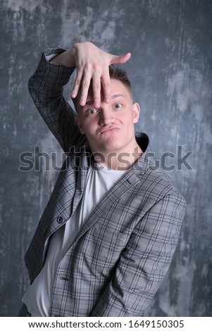 interesting portrait of an emotional classy stylish young man in a white T-shirt and jacket on a bright shogo background