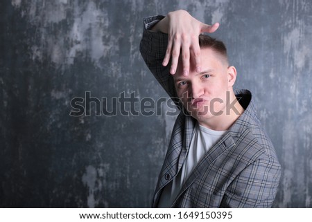 interesting portrait of an emotional classy stylish young man in a white T-shirt and jacket on a bright shogo background
