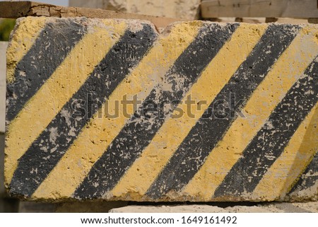 Yellow and black obstacle strip on concrete block