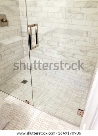 modern bathroom, walk in shower with a floor that is flush with the drain, all white marble tile