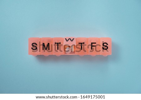 Daily pill box with medications and nutritional supplements. Royalty-Free Stock Photo #1649175001