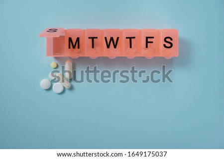Daily pill box with medications and nutritional supplements. Royalty-Free Stock Photo #1649175037