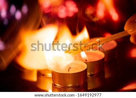 Candles and a flash of flame in the dark