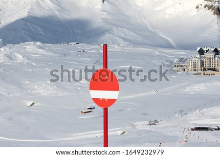 Sunlit red marker on snowy ski slope in high winter mountains. Caucasus Mountains, Shahdagh, Azerbaijan.