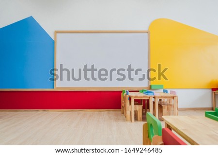 Desks, chairs and white board in the kindergarten classroom. Royalty-Free Stock Photo #1649246485