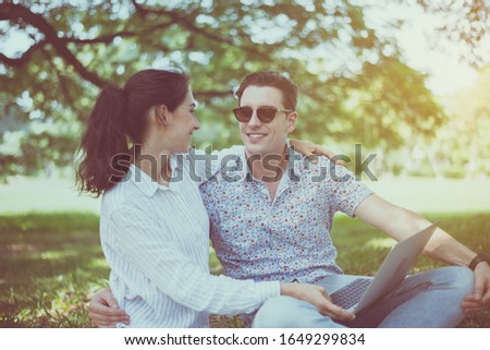 Couple young teen lover sitting and using laptop computer together at park,Romantic and enjoying in moment of happiness time,Happy and smiling
