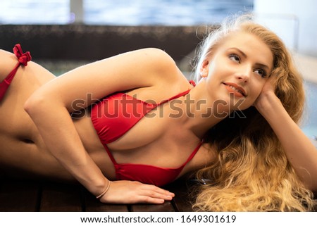 Young woman relaxing on the border of a bath tube in a spa