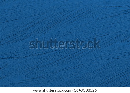 Classic blue color lipstick paint stroke surface texture background. Pantone color of the year.