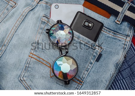 Designer glasses with kaleidoscope lenses, two smartphones are in your jeans pocket