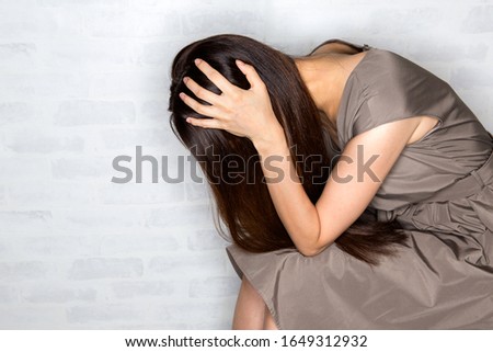 A woman holding her head. Royalty-Free Stock Photo #1649312932