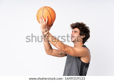 Young caucasian man over isolated white background playing basketball