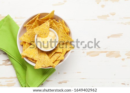 Mexican nachos chips with cheese sauce. Top view flat lay on wooden table with copy space Royalty-Free Stock Photo #1649402962