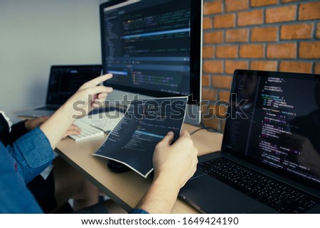 Developing programming and coding technologies working in a software engineers developing applications together in office.