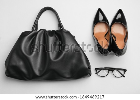 Stylish woman's bag, shoes and glasses on light grey background