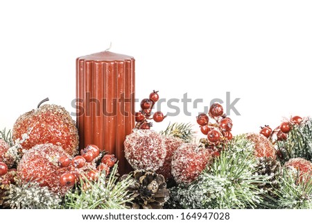 A Christmas themed flower arrangement with a red candle isolated on a white background.