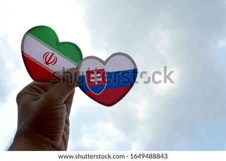 Hand holds a heart Shape Iran and Slovakia flag, love between two countries