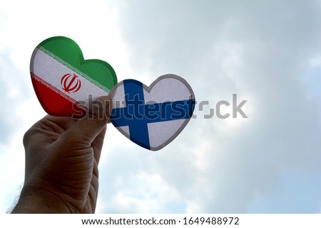 Hand holds a heart Shape Iran and Finland flag, love between two countries