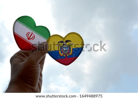 Hand holds a heart Shape Iran and Ecuador flag, love between two countries
