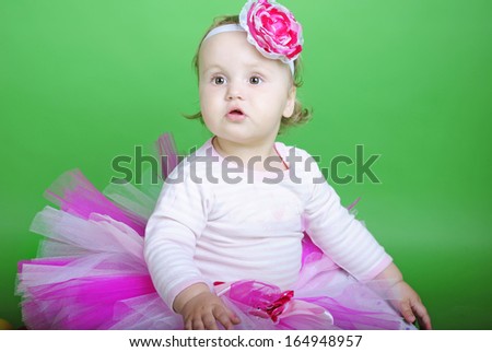 Small girl in rose suit on green background 