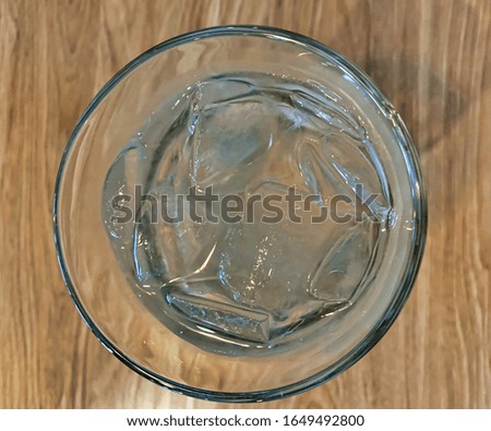 Top view of a glass of water with ice cubes.