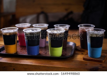 variant of cold drinks with fruit flavor. fresh cafe menu with dark background. colorful ice mockups with plastic cups. grape, chocolate, strawberry, mango, grass jelly,  blueberries, guava