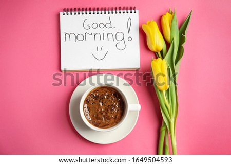 Delicious coffee, beautiful flowers and GOOD MORNING wish on pink background, flat lay