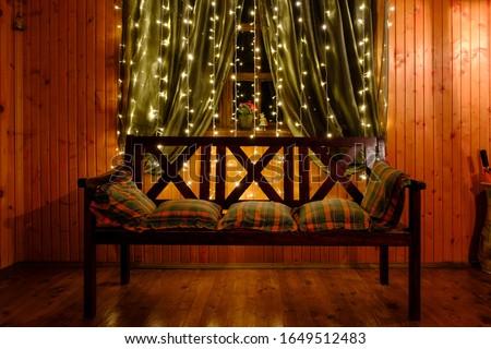 Glowing yellow festive LED garland hanging on the curtains. Selective focus Royalty-Free Stock Photo #1649512483