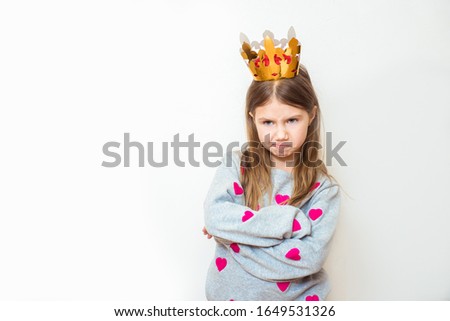 Evil child girl with a crown on a white background