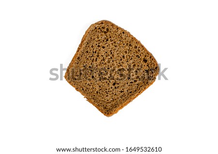 A single slice of rye bread on a white background. Top view on one rectangular slice of traditional yeast bread. Selective focus. Close-up. Landscape photo arrangement.