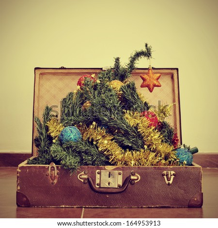 picture of a christmas tree coming out of an old suitcase, with a retro effect