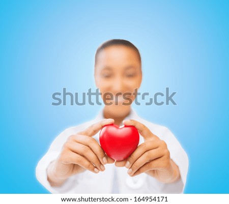 health and charity concept - close up of woman hands holding heart