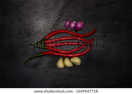 Spicy green chillies, Spicy red chillies, garlic, ​​shallots isolated from black background. capture top view.