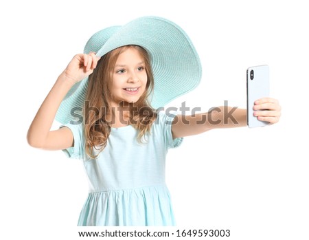Cute little girl taking selfie on white background