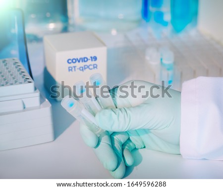 Test kit to detect novel COVID-19 coronavirus in patient samples. RT-PCR kit reagents convert viral Covid19 RNA to DNA and amplify specific region of 2019-nCov. Hand in glove holding test tubes. Royalty-Free Stock Photo #1649596288