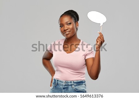 party props, photo booth and communication concept - happy african american young woman holding blank speech bubble over grey background Royalty-Free Stock Photo #1649613376