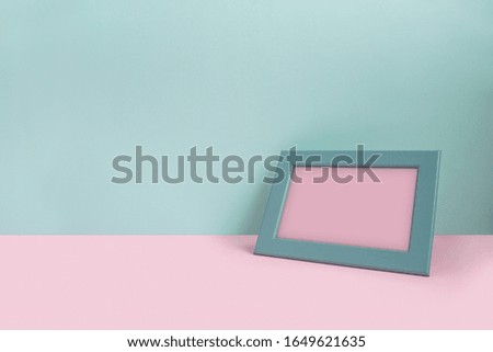 Empty frame on bright colored background. Mint and pink colors