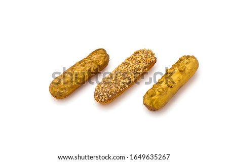 Golden Eclairs with nuts and gold glaze isolated on white background.