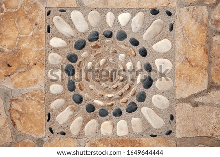 Old stone road pavement with decorative ornament, background photo texture