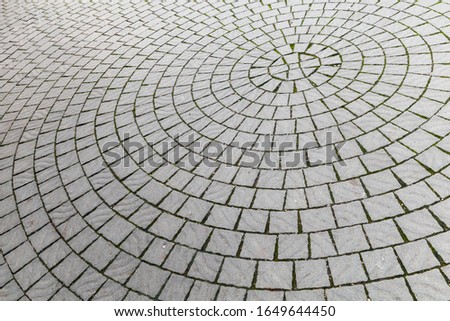Cobbled road, round pattern of a stone street pavement, abstract background photo texture