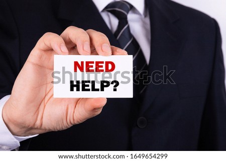 Businessman holding a card with text need help