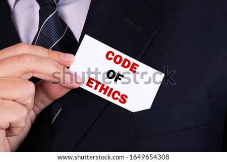 Businessman putting a card with text code of ethics in the pocket Royalty-Free Stock Photo #1649654308