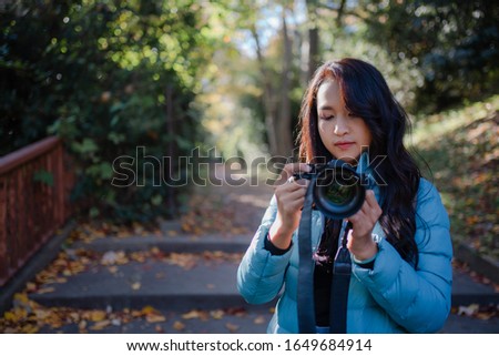 Asian young woman walking in the park with colorful maple leaves or Momijigari in autumn at Japan for relaxation. 