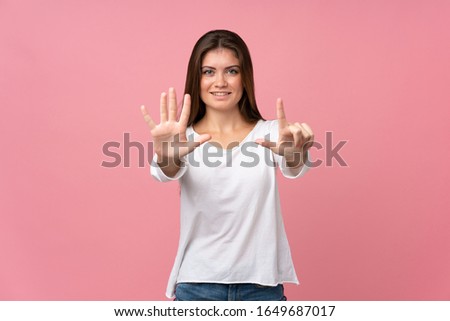 Young woman over isolated pink background counting seven with fingers