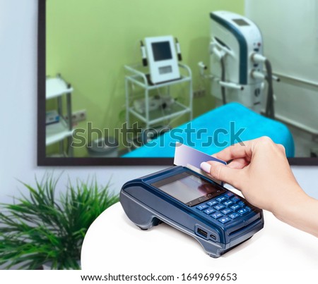 Clinic of aesthetic medicine. Payment by card.  Modern payment blue terminal.