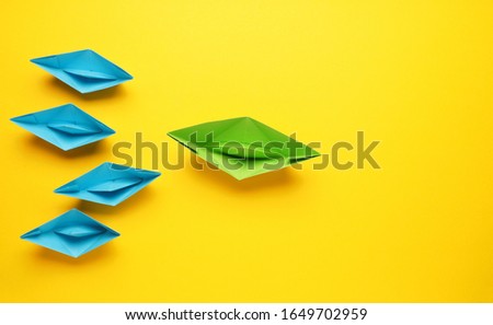 Teamwork business concept with paper boat on yellow background, view from above with space for text