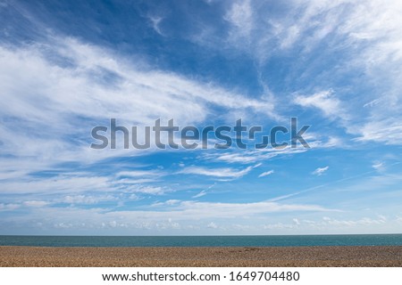 Empty beach with horizon, blue sky and wispy cloudscape. Aldeburgh, Suffolk UK.  Royalty-Free Stock Photo #1649704480