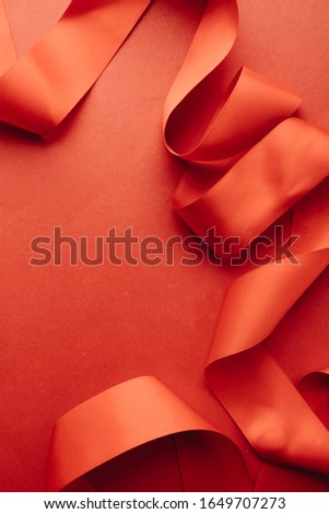 Red ribbon decoration on red background 