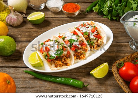 Tacos with chicken and vegetables traditional Mexican dish on a wooden rustic table with ingredients. Selected focus