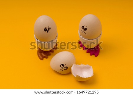 Eggs with funny faces on yellow background