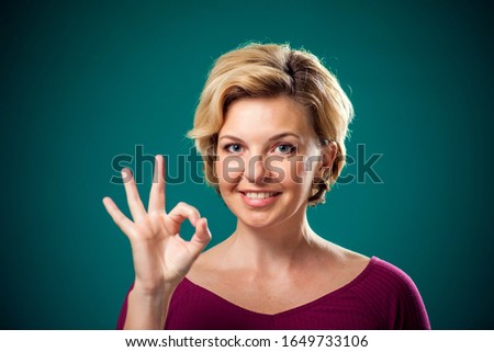 Woman with short blond hair showing okay gesture. People,lifestyle and emotions concept